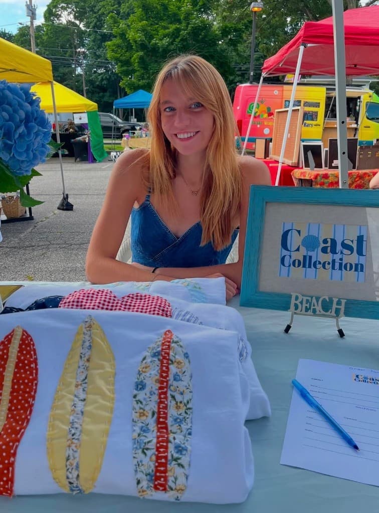 Coast Collection at a market table with the seashell wordmark and appliqué shirts